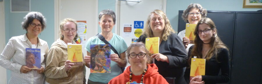 Happy learners and volunteers holding author Deb Ellis's book.