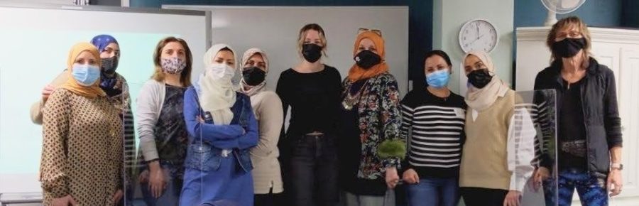 Group photo of a group of women wearing face masks, in a learning centre.