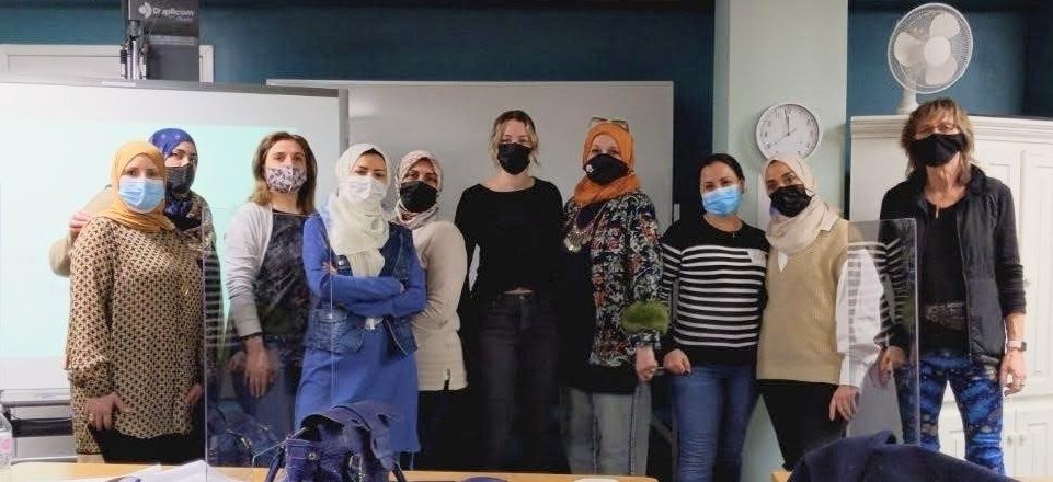 Group photo of a group of women wearing face masks, in a learning centre.
