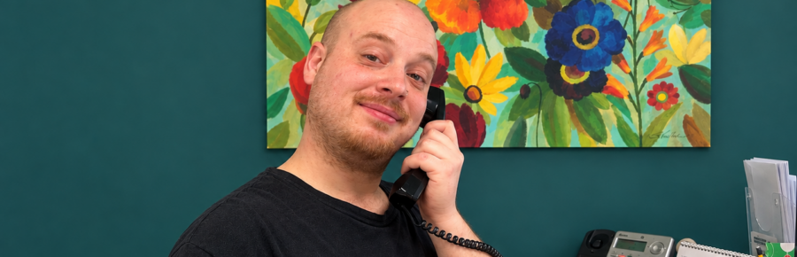 Smiling Action Read male volunteer answering the phone.