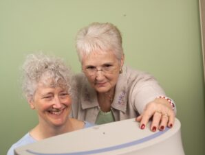 Happy tutor learner pair of women looking at a computer.