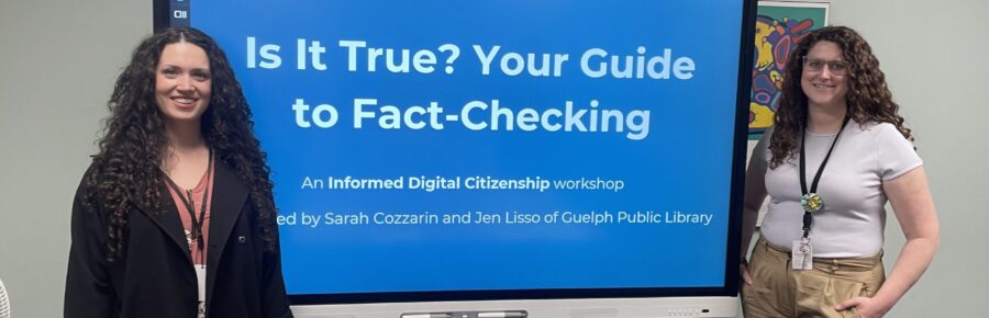 Photo of two presenters standing in front of a smart board, with the words 'Is it True? Your Guide to Fact-Checking' written on it.
